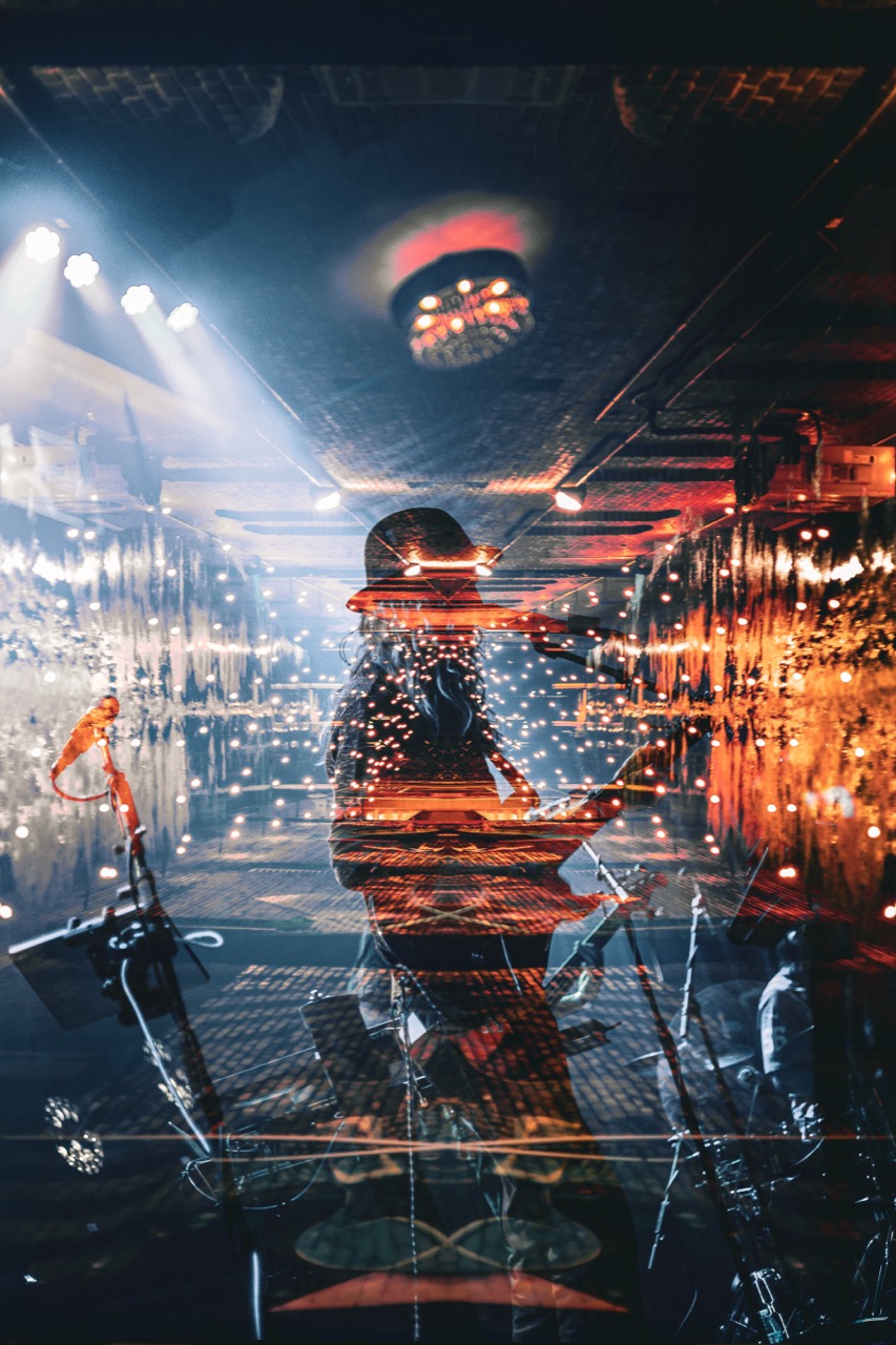 Mirrored kaleidoscope effect of Dizgo drummer with warm orange disco-ball lighting