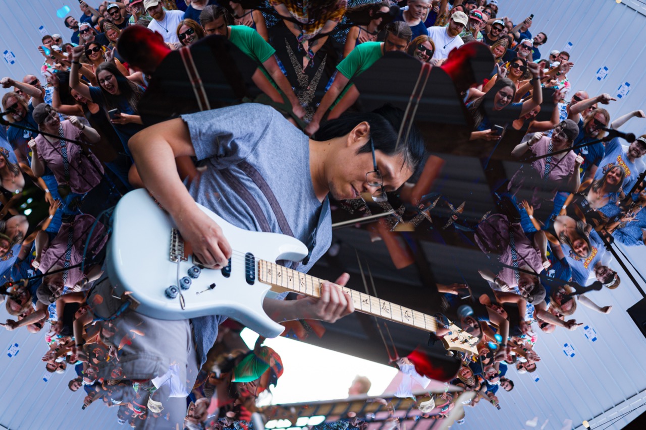 Hot Brown Smackdown guitarist in kaleidoscope mirror effect at outdoor daylight festival