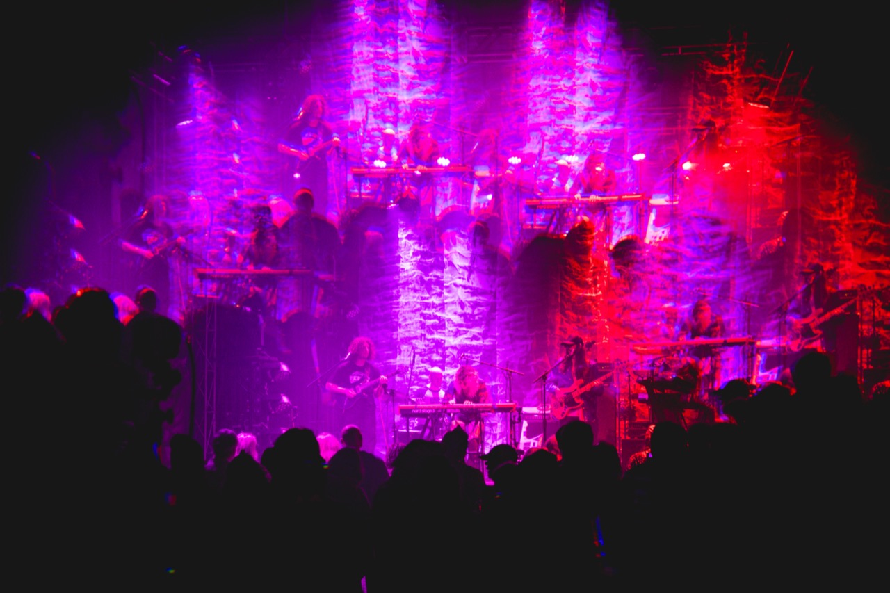 Wide stage shot of Natalie Brooke band with magenta motion-blur and crowd silhouettes